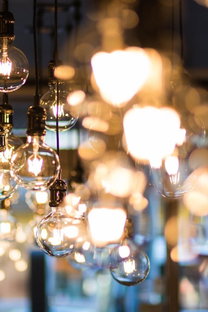 A modern and ambient urban setting with glowing, hanging light bulbs in focus.